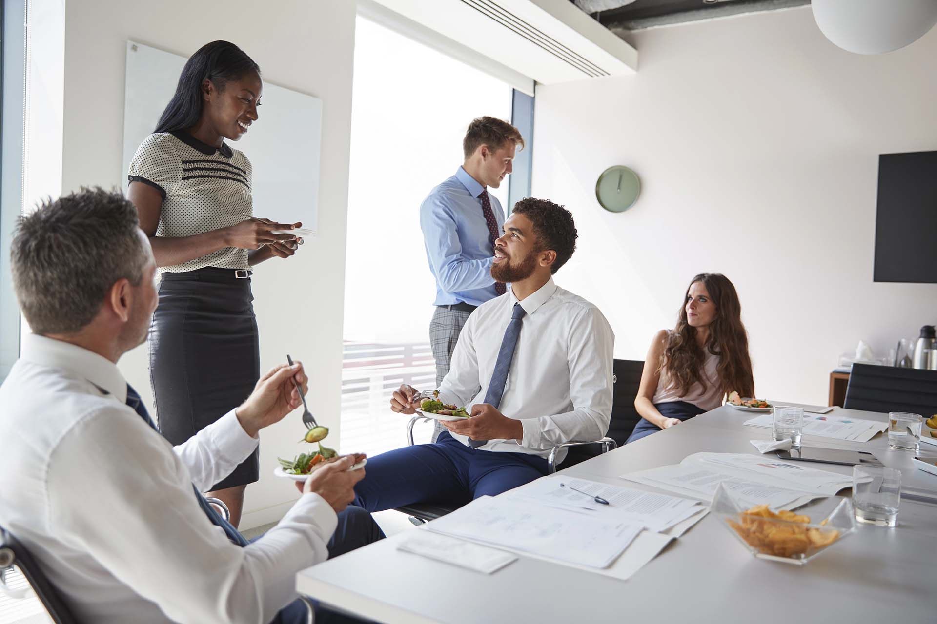 Group of people meeting in modern boardroom over working lunch